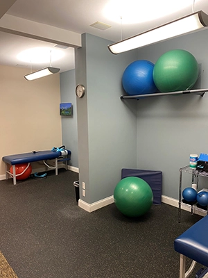 Exercise area with stability balls and treatment tables in a chiropractic clinic.