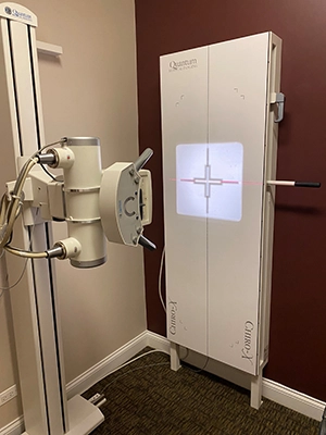 An X-ray machine in a clinical setting, labeled 'Quantum Q-Rad,' used for radiographic imaging.