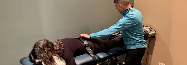 A person receiving chiropractic or physical therapy treatment with equipment applied to their lower back from Dr. Andrew Knecht.